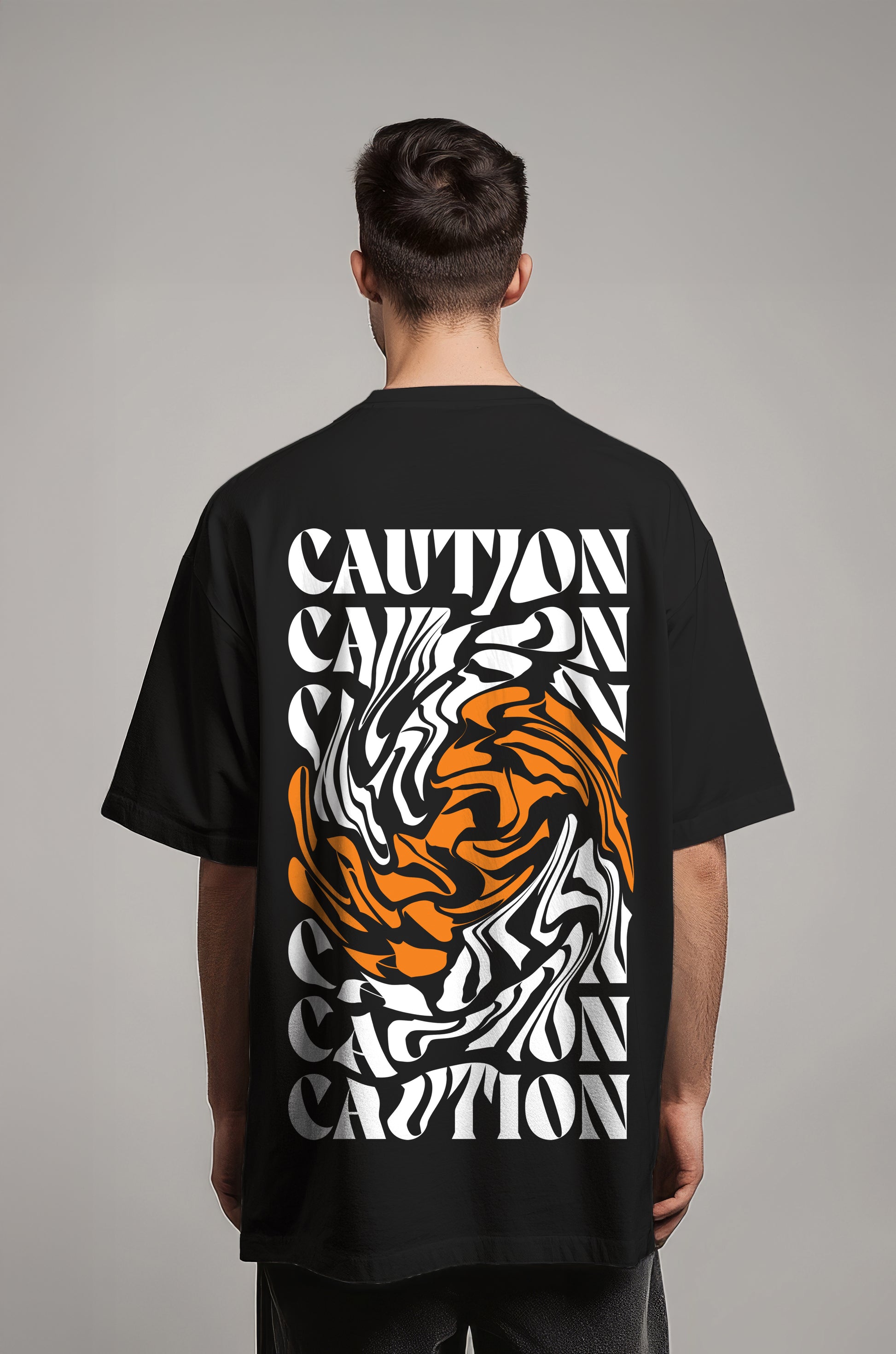 Person wearing a black t-shirt with a tiger design and 'CAUTION' text on the back against a gray background